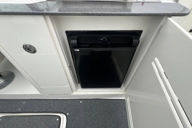 Slide: The Image of 2011 Sea Ray 300 Sundeck interior with built-in mini fridge and countertop. - 9
