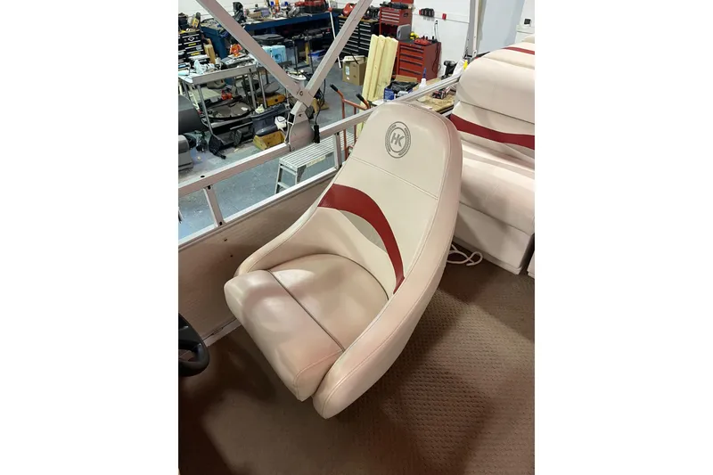 Slide: The Image of 2002 Harris FloteBote 220 Super Sunliner seat with red accents in a workshop setting. - 4