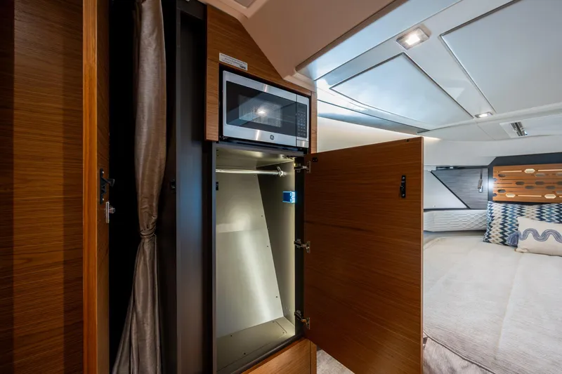 Slide: The Image of Interior of 2022 Tiara Yachts 43 LE featuring a microwave and storage cabinet. - 15