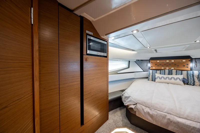 Slide: The Image of Luxurious interior of 2022 Tiara Yachts 43 LE, featuring a cozy bedroom and modern wood finishes. - 16