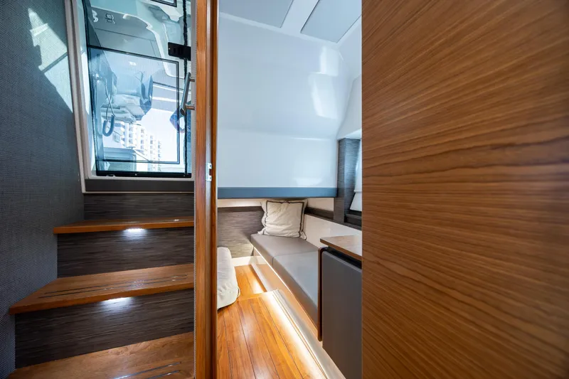 Slide: The Image of Interior of 2022 Tiara Yachts 43 LE, featuring wooden stairs and cozy seating area. - 23