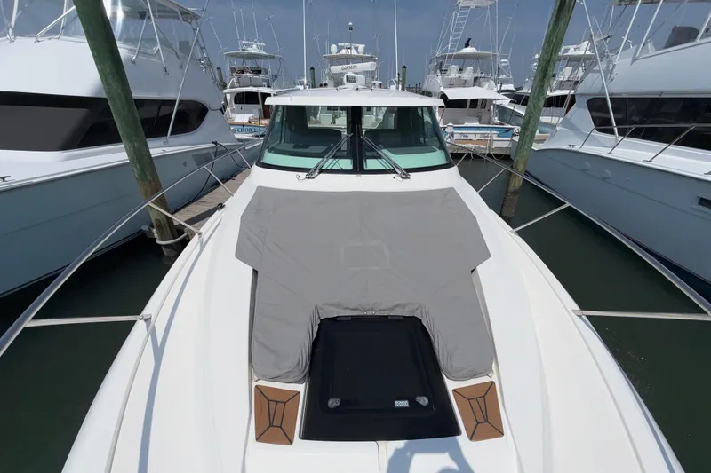 Slide: The Image of 2022 Tiara Yachts 43 LE docked among other boats, showcasing sleek design and spacious deck. - 3
