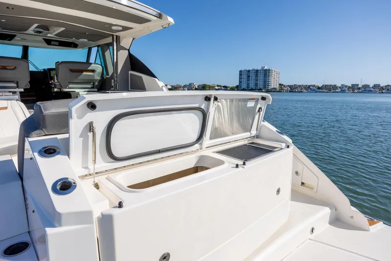 Slide: The Image of 2022 Tiara Yachts 43 LE boat with open storage compartment, docked by waterfront. - 33