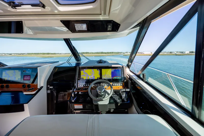 Slide: The Image of Cockpit view of 2022 Tiara Yachts 43 LE, featuring advanced navigation systems and scenic waterway. - 45