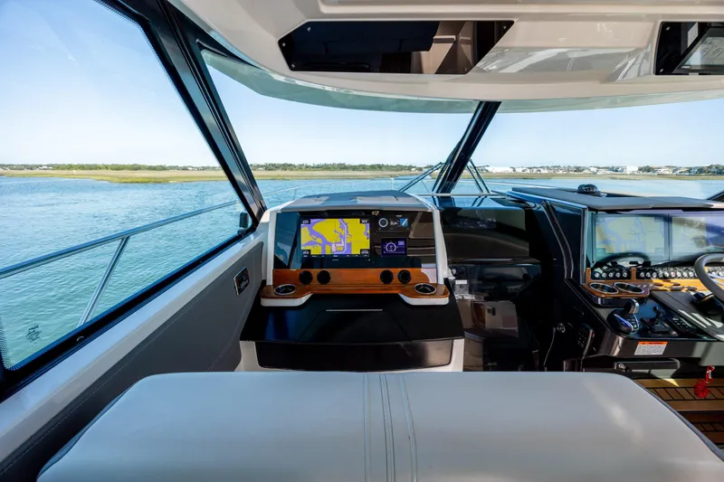 Slide: The Image of Interior view of 2022 Tiara Yachts 43 LE helm with navigation screens and scenic waterway. - 48