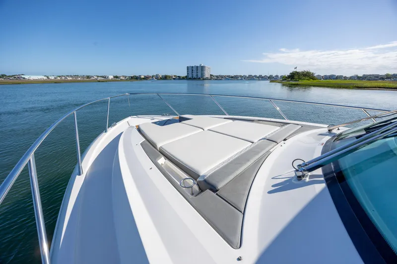 Slide: The Image of 2022 Tiara Yachts 43 LE cruising on a serene waterway under a clear blue sky. - 69