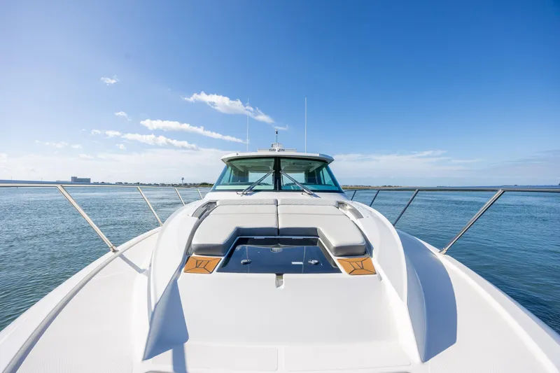 Slide: The Image of 2022 Tiara Yachts 43 LE on calm water under clear blue sky. - 70