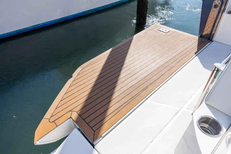 Slide: The Image of 2022 Tiara Yachts 43 LE swim platform with teak decking, docked by the water. - 75