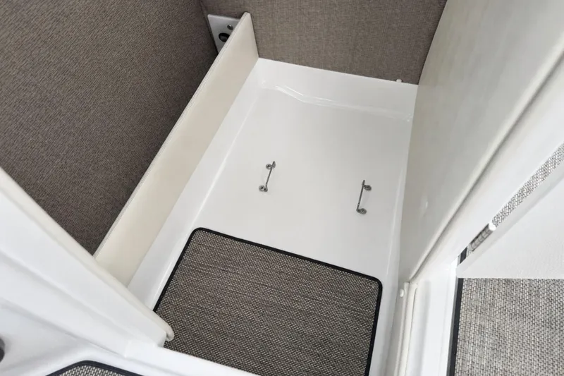 Slide: The Image of 2016 Cobalt R5 boat interior storage compartment with carpeted flooring and secure latches. - 17