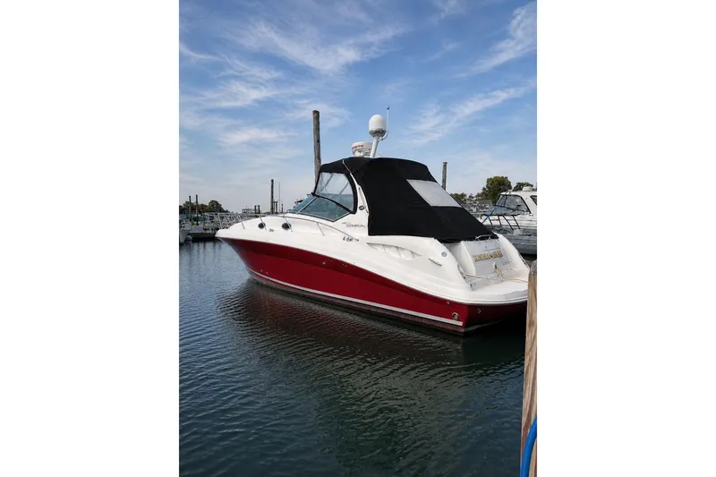 Slide: The Image of 2006 Sea Ray 340 Sundancer boat docked on calm water under a blue sky. - 3