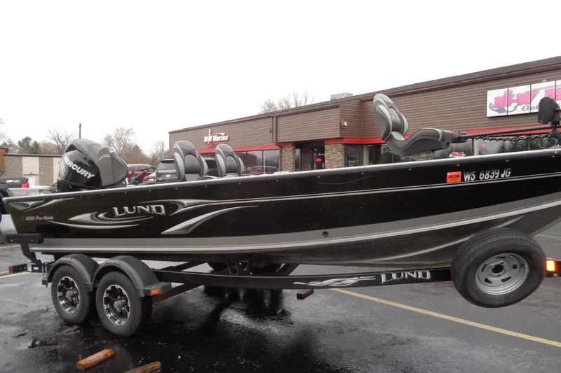Slide: The Image of 2011 Lund 2010 Pro Guide boat on trailer in parking lot. - 11