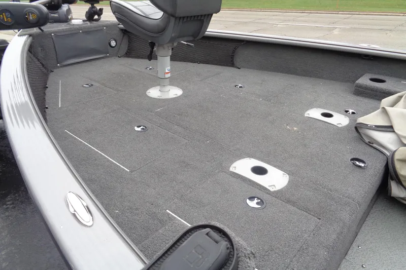 Slide: The Image of 2011 Lund Pro Guide boat interior with gray carpet and swivel seat. - 14