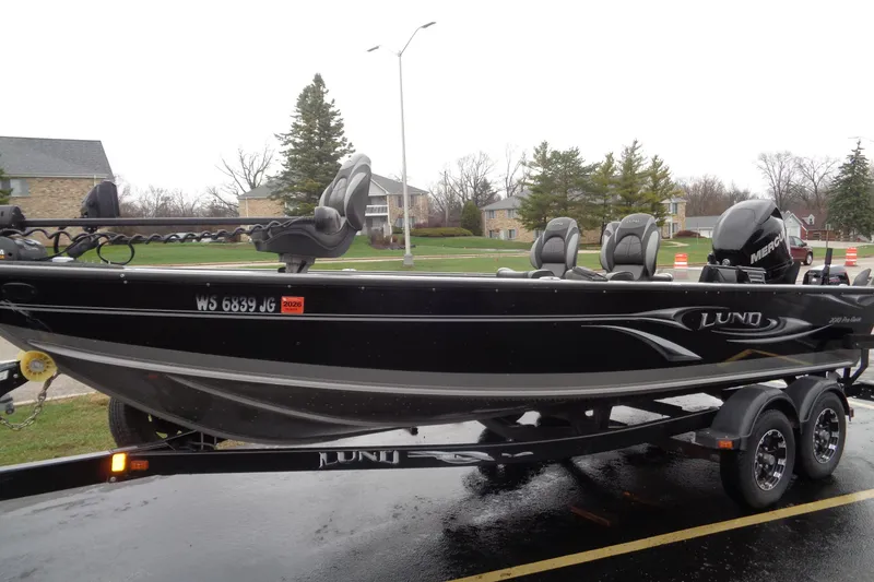 Slide: The Image of Lund 2010 Pro Guide boat on trailer, parked outdoors, overcast day. - 2