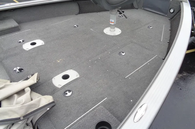 Slide: The Image of 2011 Lund 2010 Pro Guide boat interior with gray carpet and seating area. - 23