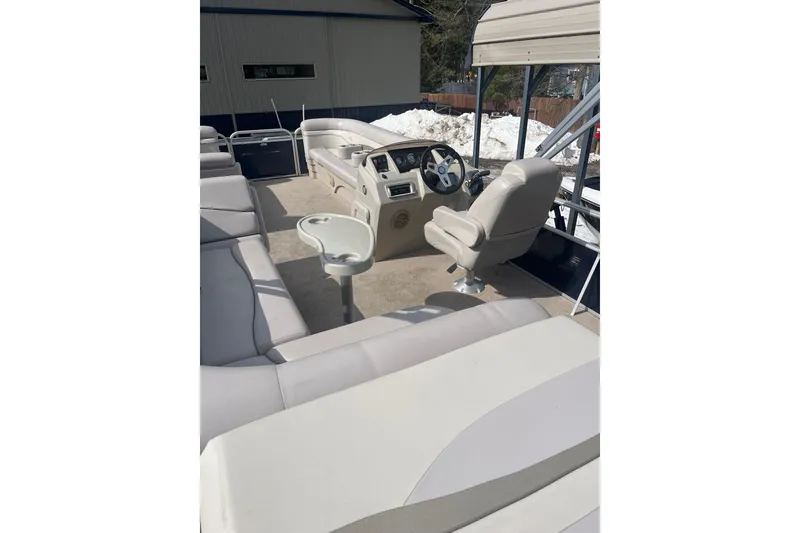 Slide: The Image of 2014 Bennington 22 SLX pontoon boat interior with beige seating and steering console. - 4