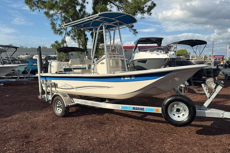 The Image of 2019 Carolina Skiff 18 JVX CC boat on trailer, parked outdoors under a blue sky. - 0