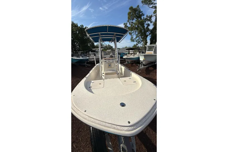 Slide: The Image of 2019 Carolina Skiff 18 JVX CC boat with blue canopy, parked outdoors. - 7