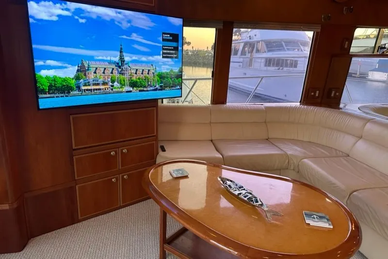 Slide: The Image of Luxurious interior of 1999 Mikelson 64 yacht with leather seating and large TV. - 11
