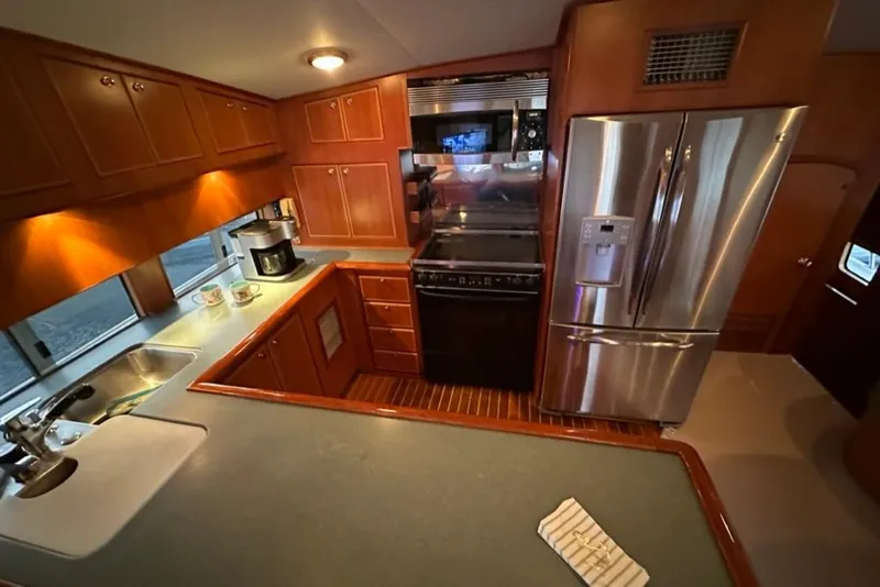 Slide: The Image of Luxurious kitchen interior of a 1999 Mikelson 64 Long Range Sportfish yacht with modern appliances. - 17