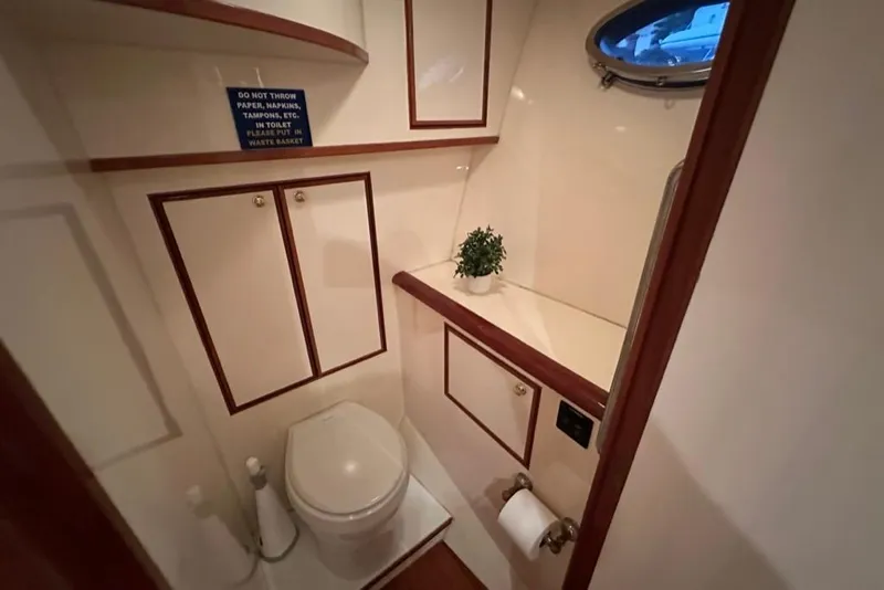 Slide: The Image of Luxurious bathroom in a 1999 Mikelson 64 Long Range Sportfish yacht, featuring elegant wood accents. - 28
