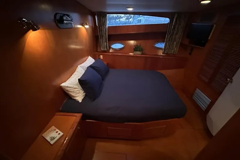 Slide: The Image of Luxurious cabin interior of a 1999 Mikelson 64 Long Range Sportfish yacht, featuring cozy bedding. - 32