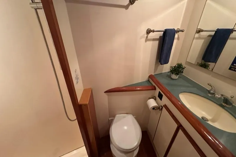 Slide: The Image of Bathroom interior of 1999 Mikelson 64 Long Range Luxury Sportfish yacht, featuring sink and toilet. - 44