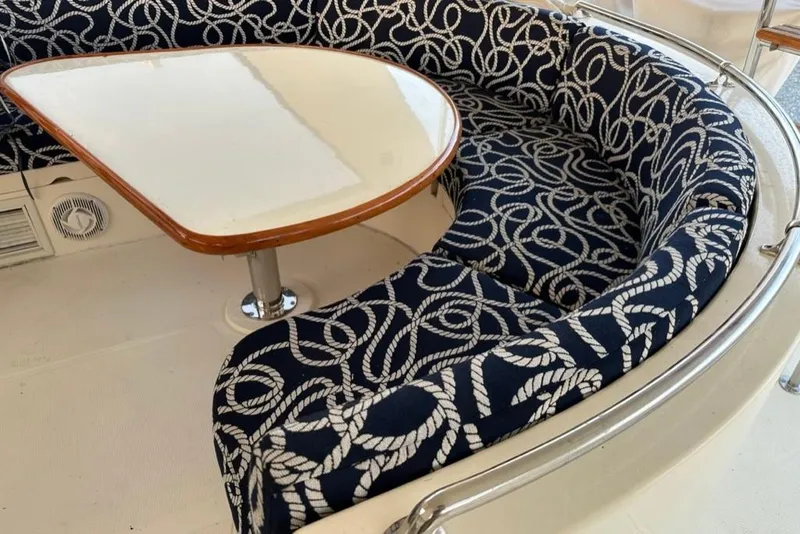 Slide: The Image of Luxury seating area on 1999 Mikelson 64 Long Range Sportfish yacht with nautical-themed upholstery. - 49