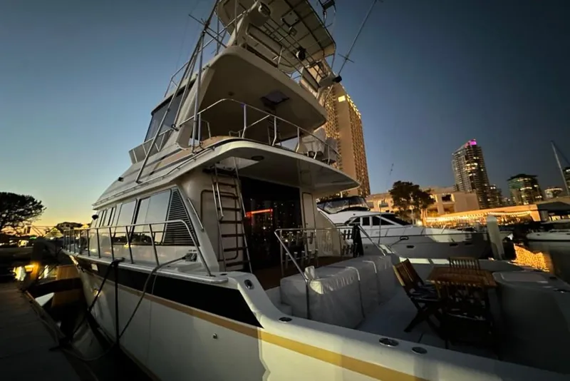 Slide: The Image of 1999 Mikelson 64 Long Range Luxury Sportfish yacht docked at sunset in a city marina. - 59