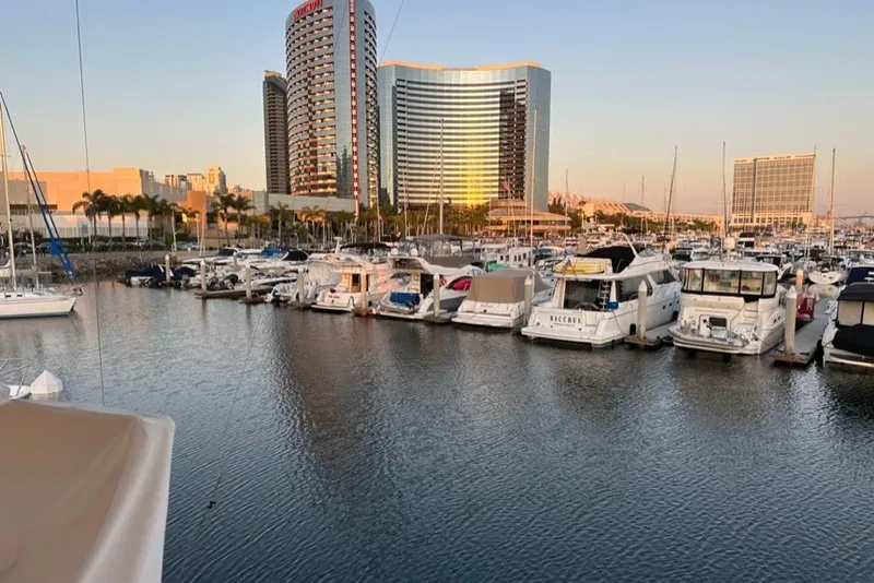 Slide: The Image of Marina with luxury yachts, including a 1999 Mikelson 64 Long Range Sportfish, at sunset. - 64
