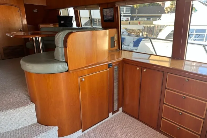 Slide: The Image of Interior of 1999 Mikelson 64 Long Range Luxury Sportfish yacht with wood cabinetry and seating. - 8
