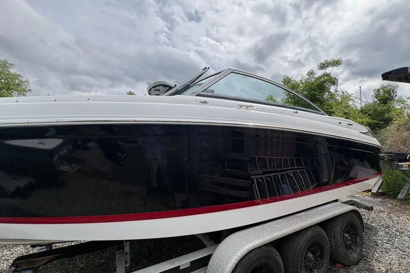 The Image of 2013 Cobalt 242 boat on trailer under cloudy sky. - 0