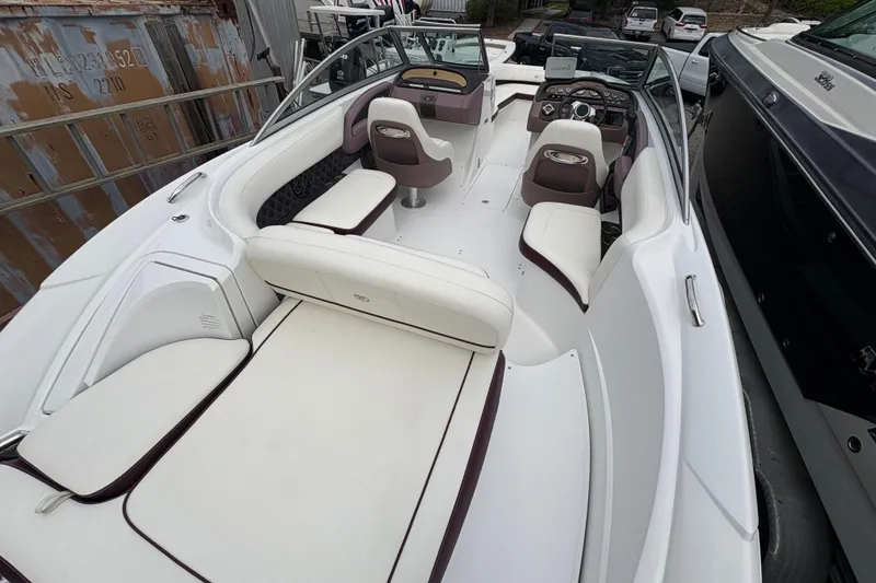 Slide: The Image of 2013 Cobalt 242 boat interior with white and brown seating, sleek design, and modern dashboard. - 10