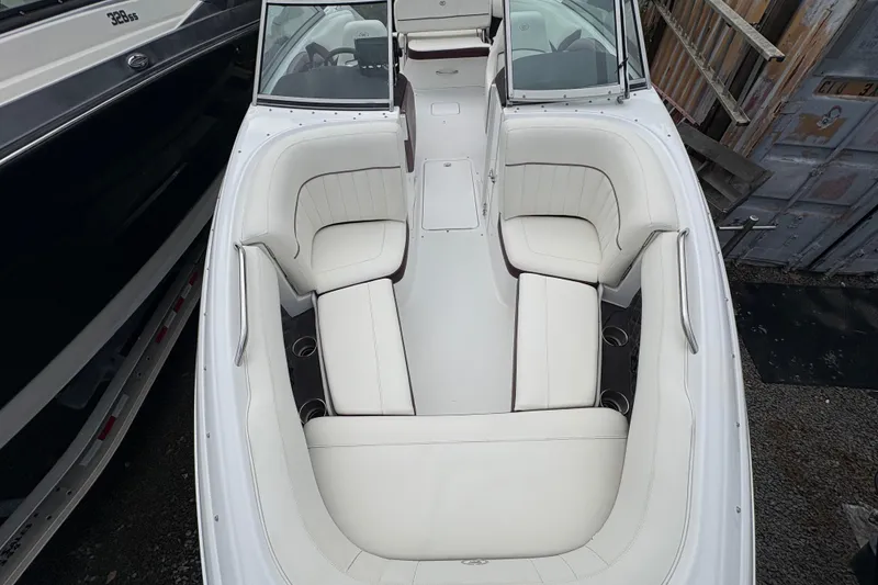 Slide: The Image of 2013 Cobalt 242 boat interior with white seating and cup holders. - 3