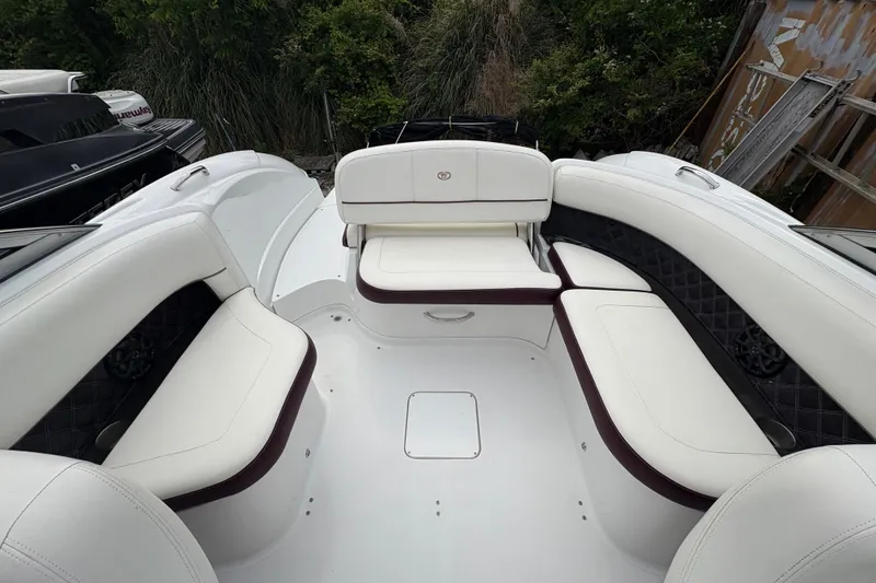 Slide: The Image of Luxurious seating area on a 2013 Cobalt 242 boat, featuring white and maroon upholstery. - 7