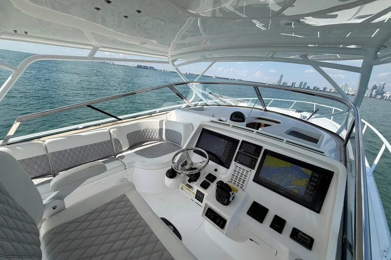 Slide: The Image of 2017 Intrepid 475 Sport Yacht helm with advanced navigation systems, cruising on open water. - 14