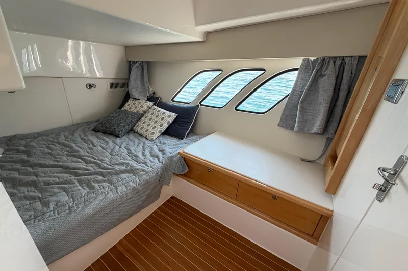 Slide: The Image of Cozy cabin interior of 2017 Intrepid 475 Sport Yacht with bed and porthole windows. - 16