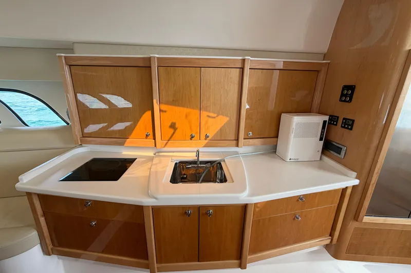 Slide: The Image of 2017 Intrepid 475 Sport Yacht kitchen with wooden cabinets and modern appliances. - 19