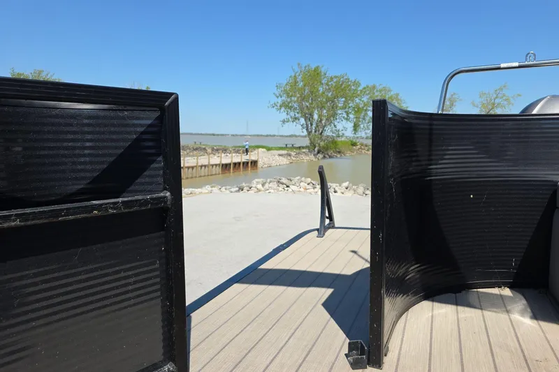 Slide: The Image of 2020 Bennington SX 22 SSLDX pontoon boat at a lakeside dock under clear blue skies. - 11