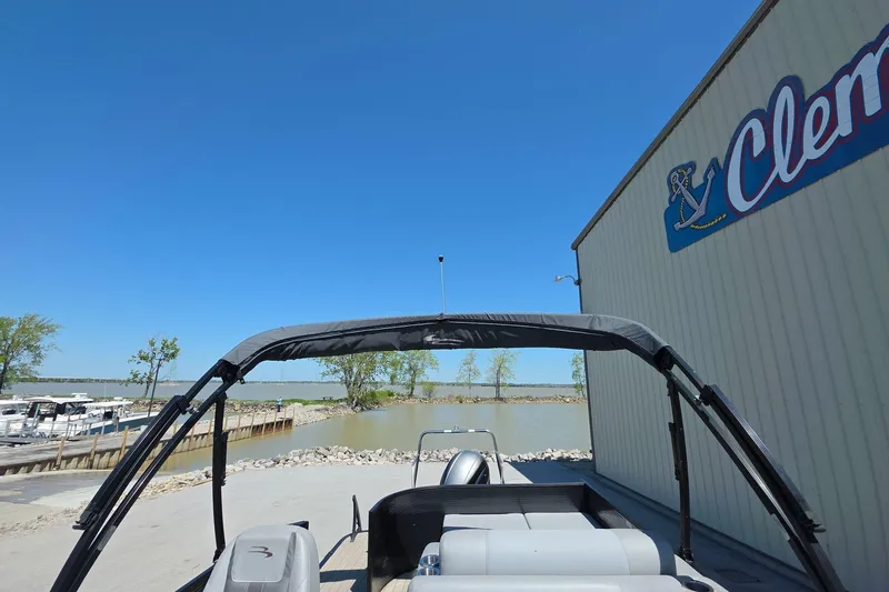 Slide: The Image of 2020 Bennington SX 22 SSLDX pontoon boat near a marina under clear blue sky. - 17
