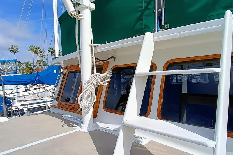 Slide: The Image of 1978 Californian LRC yacht with green canopy and wooden window frames docked at marina. - 11