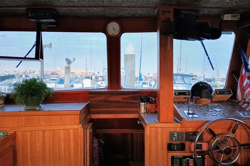 Slide: The Image of 1978 Californian LRC boat interior with wooden helm, marina view, and nautical decor. - 13