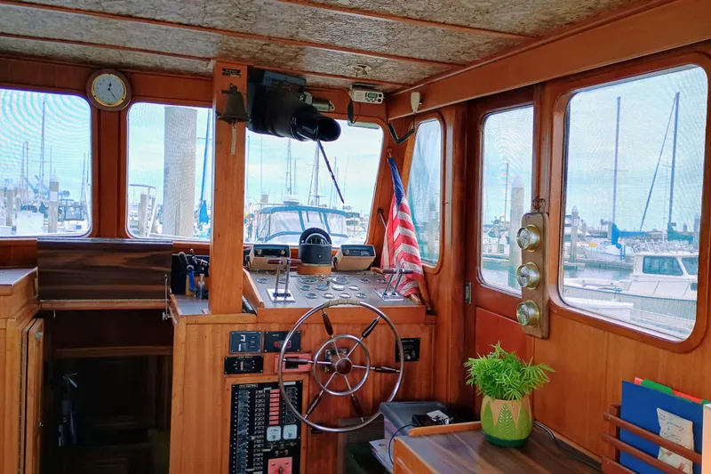 Slide: The Image of 1978 Californian LRC boat interior with wooden helm, American flag, and marina view. - 14