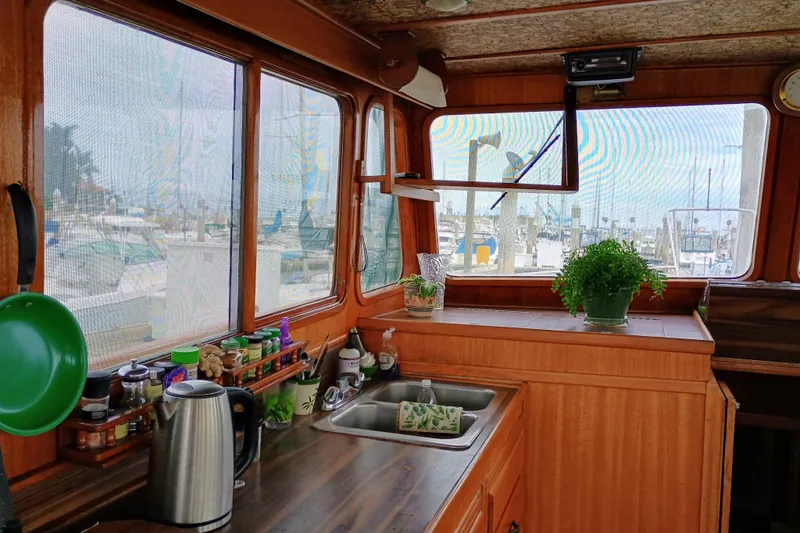 Slide: The Image of 1978 Californian LRC boat interior with kitchen, plants, and marina view. - 15