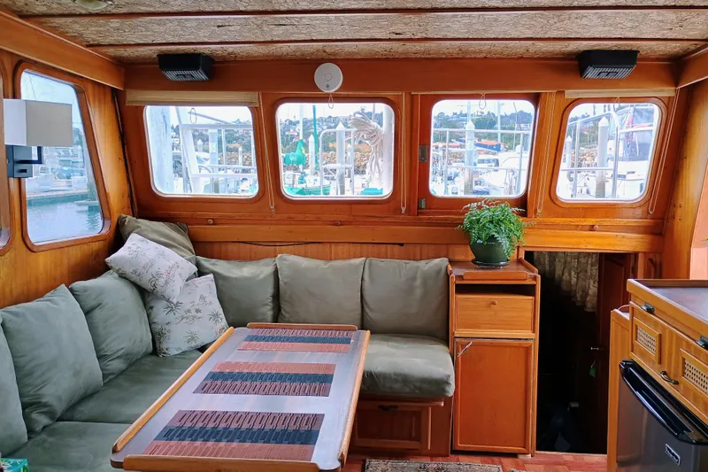 Slide: The Image of Cozy 1978 Californian LRC yacht interior with green sofa, wooden table, and potted plant. - 19