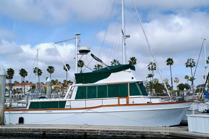 Slide: The Image of 1978 Californian LRC yacht docked at marina with palm trees and cloudy sky. - 37