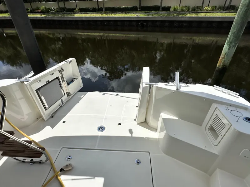 Slide: The Image of 2022 Beneteau Swift Trawler 35 deck view, featuring open storage and water reflections. - 11