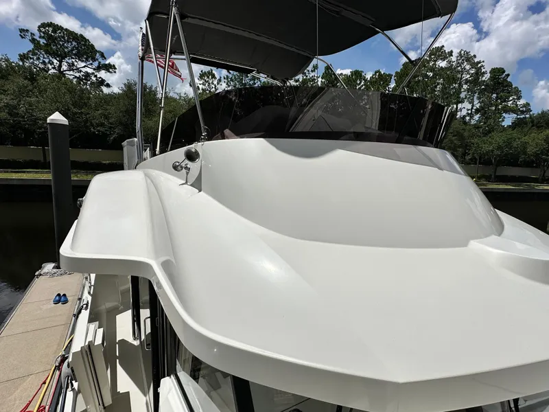 Slide: The Image of 2022 Beneteau Swift Trawler 35 docked, showcasing sleek design and flybridge under a blue sky. - 26