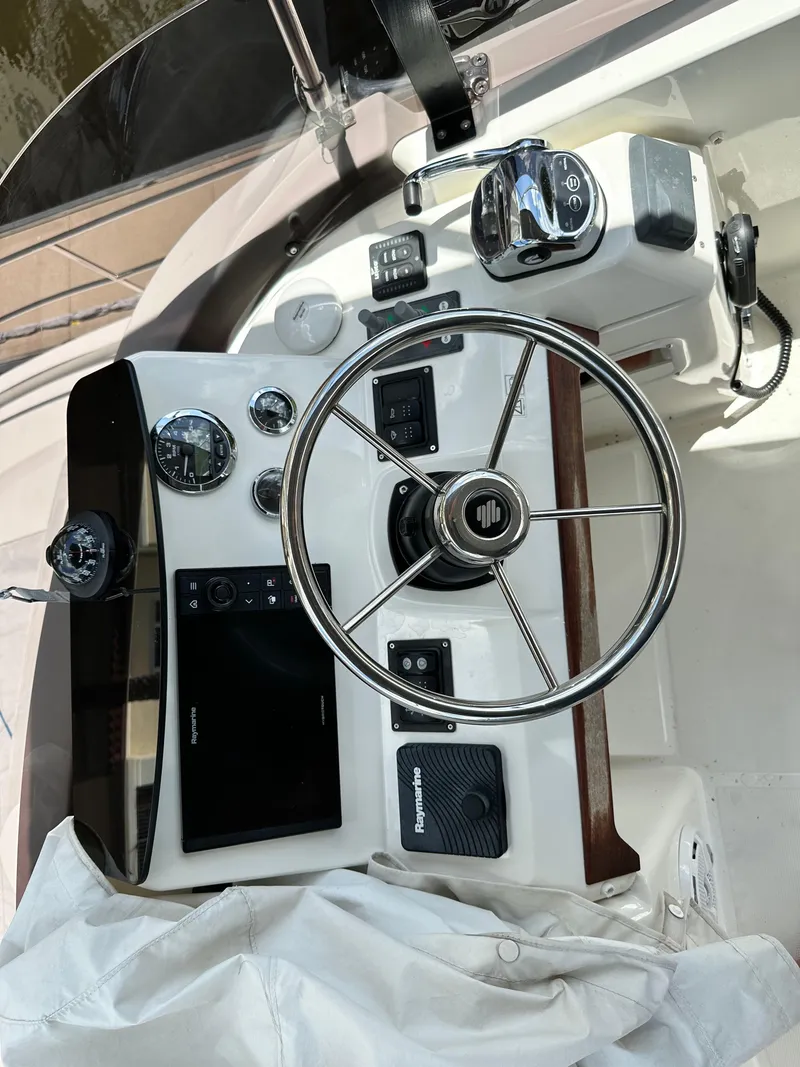 Slide: The Image of Helm of 2022 Beneteau Swift Trawler 35 with steering wheel and navigation controls. - 33