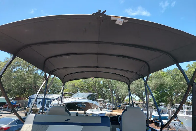 Slide: The Image of 2026 Starcraft EXS 3 Q DH boat with canopy, parked outdoors under clear sky. - 25