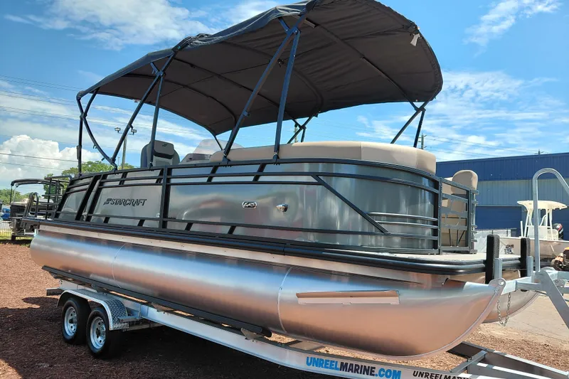 Slide: The Image of 2026 Starcraft EXS 3 Q DH pontoon boat on trailer under blue sky. - 9